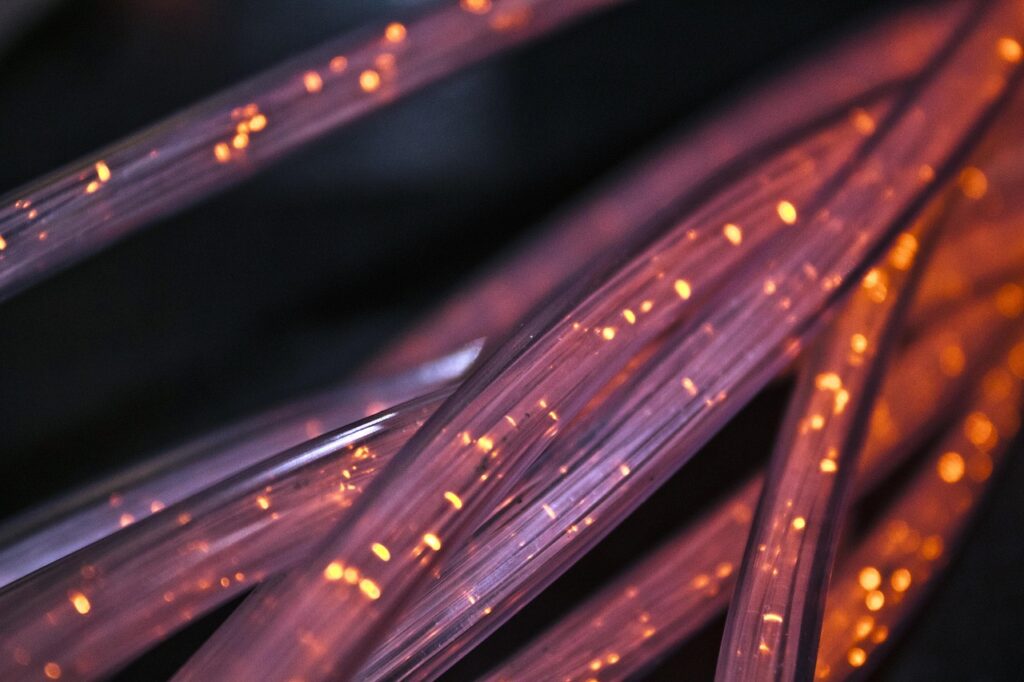Cabos de fibra óptica iluminados em close, ilustrando o marketing para provedor de internet