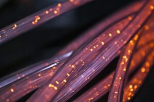 Cabos de fibra óptica iluminados em close, ilustrando o marketing para provedor de internet